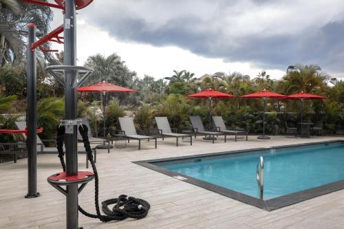 
a pool with chairs and umbrellas in it at The Locale Hotel Grand Cayman in George Town
