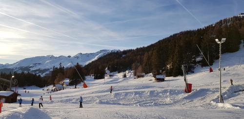 a group of people skiing down a snow covered slope at Rue de Bel-Aube Chalet Joli 10 in Crans-Montana