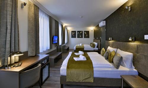 Habitación de hotel con 2 camas y TV en Herbstyle, en Eger