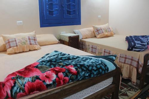 a room with two beds with a blanket on them at Tunis Village Chalet in Fayoum Center