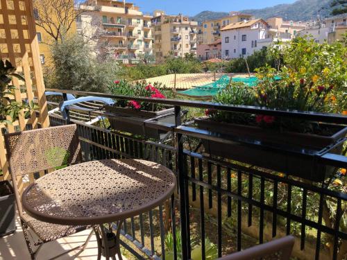 una mesa y sillas en un balcón con flores en Appartamento Le Zagare, en Sorrento