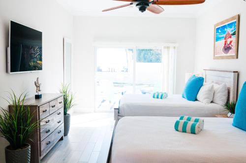 two beds in a white room with blue accents at Seascape Resort & Marina in Marathon