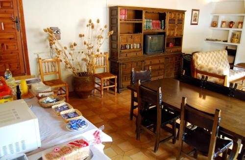 een eetkamer met een tafel, stoelen en een televisie bij La Noguera in Palomera