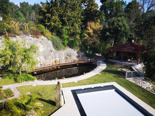 a swimming pool in a garden with a gazebo at Cantinho do Lucas in Alvaiázere