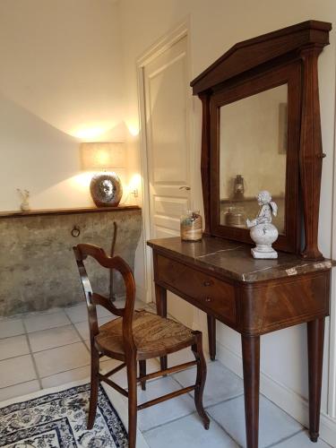 a wooden desk with a chair and a mirror at Jardin de Mathilde in Nangis