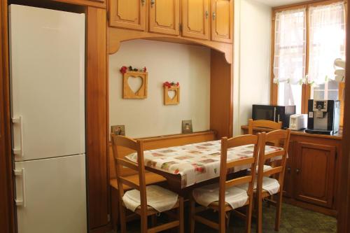 a kitchen with a table and chairs and a refrigerator at lesboisjolis in Colmar