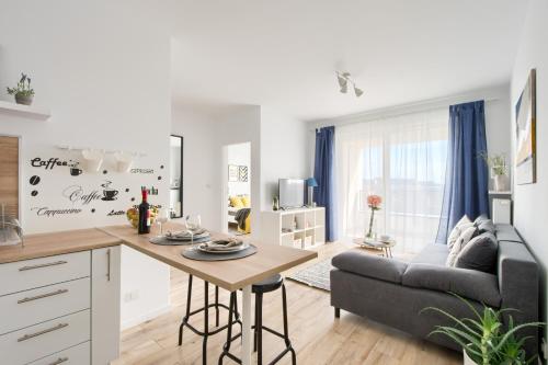 kuchnia i salon ze stołem i kanapą w obiekcie M&R Apartament Airport&Business Premium Komputerowa - underground garage - free WiFi - Netflix - self check-in - 5 min from Chopin Airport w Warszawie