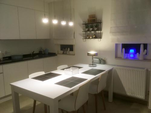 a kitchen with a white table and white cabinets at DUINLICHT-Oostduinkerke in Oostduinkerke