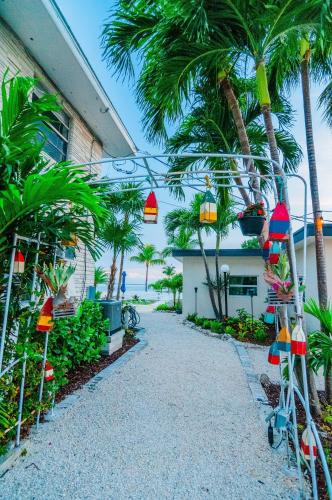 a walkway with palm trees and lights next to a building at Seascape Resort & Marina in Marathon