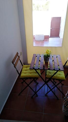 a wooden table and chairs in a room with a window at Casa BENVINDHA in Degolados