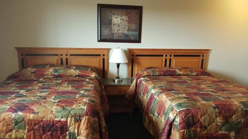 two beds sitting next to each other in a hotel room at Sunrise Motel in Regina