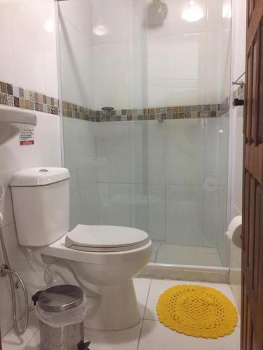 a bathroom with a white toilet and a shower at Pousada Temporada in Arraial do Cabo
