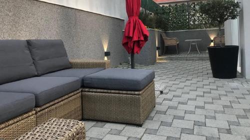 a patio with a couch and an umbrella at Holiday Home Aspalathos - with free parking, near the beach, a few minutes' walking distance to the UNESCO Palace in Split