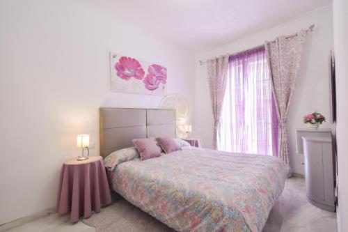 1 dormitorio con 1 cama y 2 lámparas en una mesa en Apartamento céntrico hogareño, en Málaga