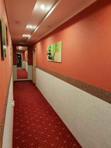 a hallway in a hospital with orange walls and a red carpet at Waldhotel und Restaurant Lemberg in Hagen