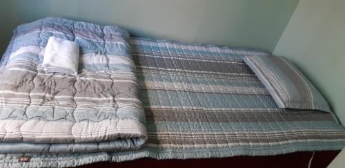 a bed with a blanket on top of it at Birdsnest Hostel Hongdae Foreigner only in Seoul