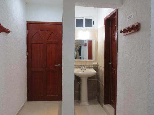 baño con puerta de madera y lavamanos en Hotel Holmar en Holbox Island