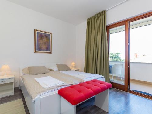 a bedroom with a large bed with a red bench at Ulika Rooms & Apartments in Poreč