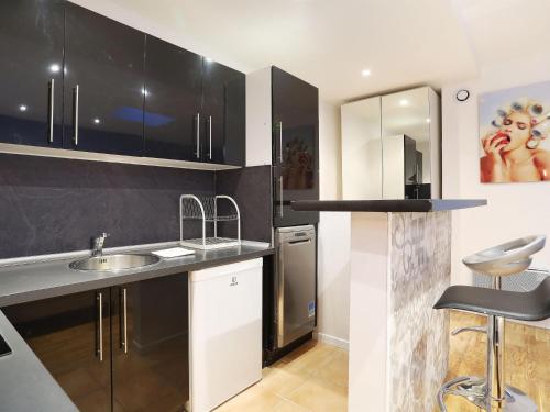 a kitchen with black and white cabinets and a sink at Rent a Room - Residence Caire, Montorgueil in Paris