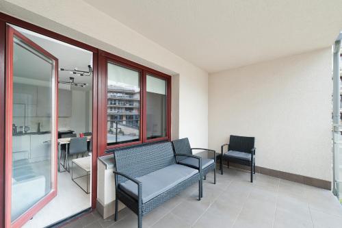 a waiting room with a chair and a table and windows at Ludwinowska11 Apartments in Kraków