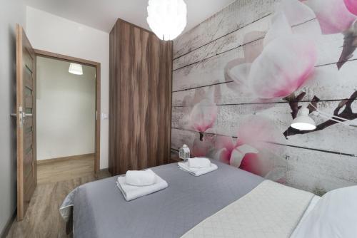 a bedroom with a bed with two towels on it at Apartament Sweet House in Olsztyn