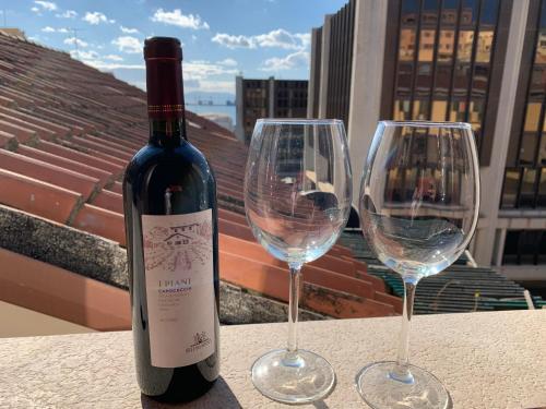 butelkę wina i dwa kieliszki wina na stole w obiekcie Flamingo Luxury Apartment AJPSARDINIA w Cagliari