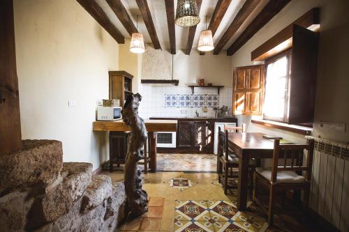 a kitchen with a table and a dining room at Orgullo Rural in Bermellar