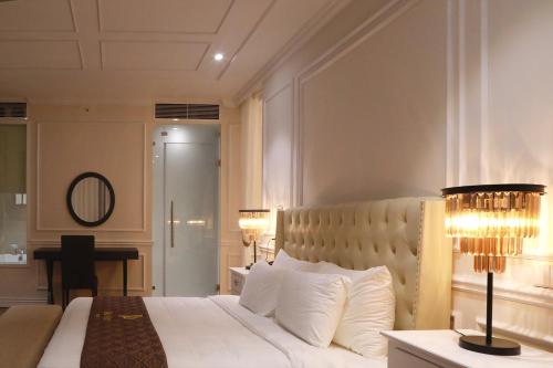 a bedroom with a large white bed and a mirror at Dai Viet Hotel in Thanh Hóa