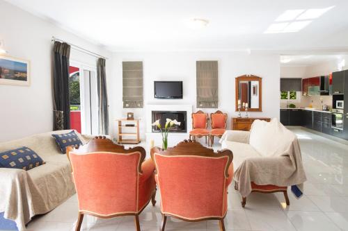 a living room with a couch and a table and chairs at Red Villa in Nydri