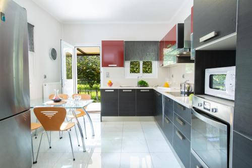 a kitchen with a table and a dining room at Red Villa in Nydri