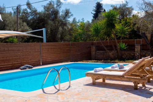 a swimming pool with a bench next to a wooden fence at Red Villa in Nydri