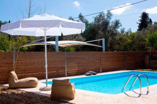 a swimming pool with an umbrella and a swimming pool at Red Villa in Nydri