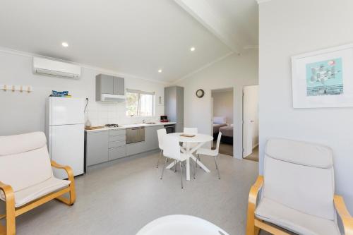 a kitchen and dining room with a table and chairs at Foxton Beach Holiday Park in Foxton Beach