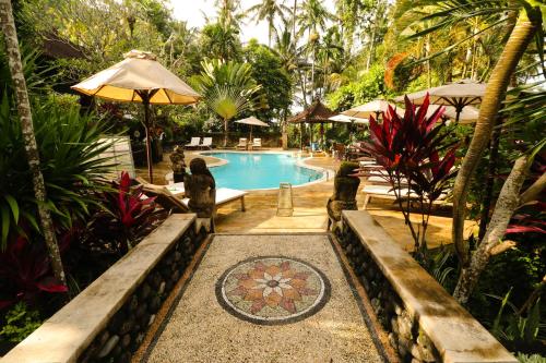 a swimming pool in a resort with a garden at Dasa Wana Resort in Candidasa