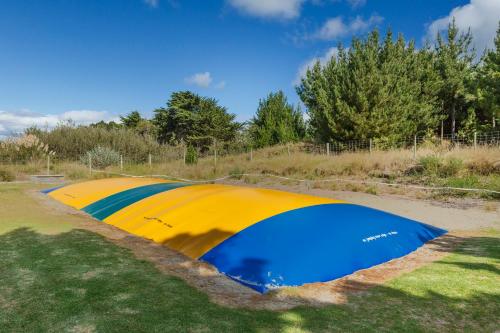 a yellow and blue tent sitting in the grass at Foxton Beach Holiday Park in Foxton Beach