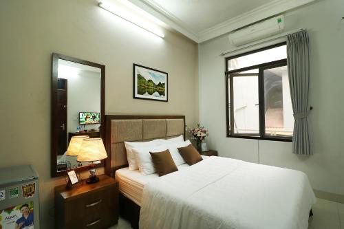 a bedroom with a white bed and a window at ISTAY Hotel Apartment 1 in Hanoi