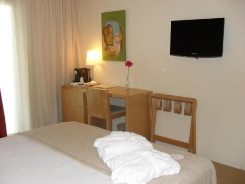 a bedroom with a bed and a television at INLIMA Hotel & Spa in Ponte de Lima