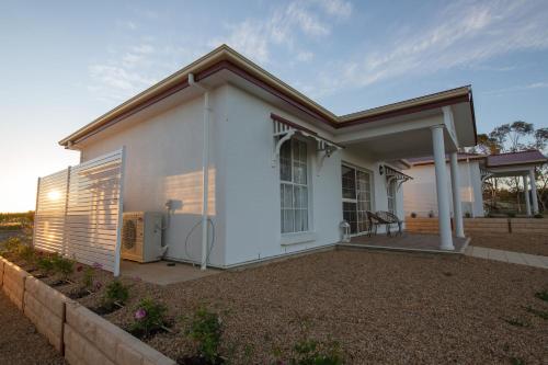 a small white house with a patio at 1837 Barossa Luxury Vineyard Cottages in Lyndoch