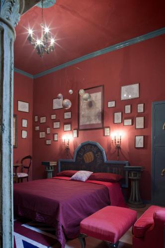 a bedroom with red walls and a bed and a chandelier at Repubblica Di Oz Rooms in Varese