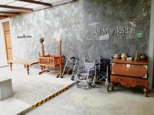 a room with a stone wall with chairs and a table at Nil Diya Mankada Safari Lodge in Udawalawe