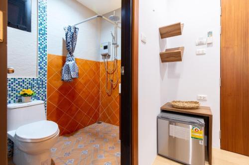 La salle de bains est pourvue d'une douche et de toilettes. dans l'établissement Lilliput Riverside Bangkachao, à Samutprakarn