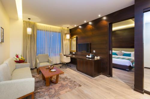 une chambre d'hôtel avec un lit et un salon dans l'établissement Diyalo Lords Plaza Birgunj, à Bīrganj