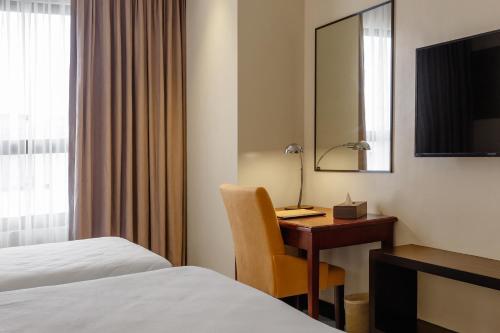 a hotel room with a desk and a bed at Summit Hotel Tacloban in Tacloban
