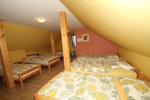 a attic bedroom with three beds in a room at Vineyard Cottage Vrbek in Roginska Gorca