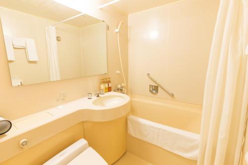 Hotel Sunroute Taipei في تايبيه: حمام مع حوض وحوض ومرآة