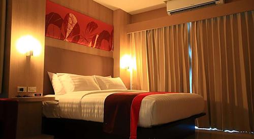 a hotel room with a bed and a window at Best Western Royal Buriram in Buriram