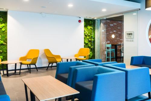 a waiting room with blue chairs and tables at Tallink Express Hotel in Tallinn