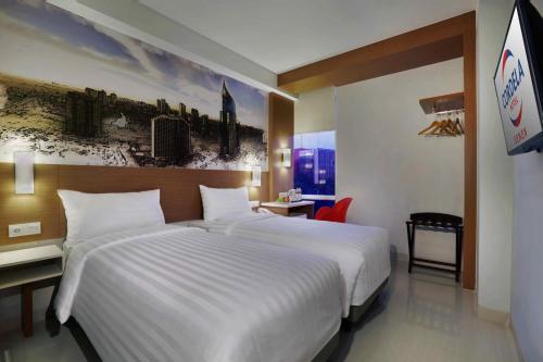 a large white bed in a hotel room at Cordela Senen Jakarta in Jakarta