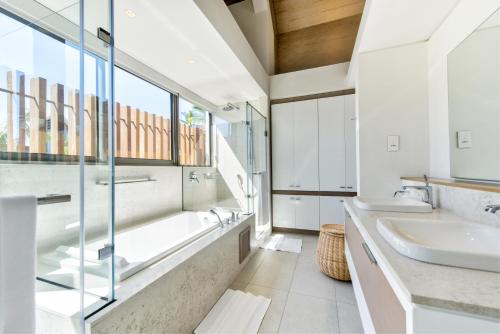 La salle de bains est pourvue de 2 lavabos et d'une grande fenêtre. dans l'établissement Mont Choisy Le Parc by Pam Golding, à Grand Baie