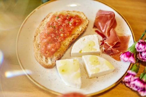 a plate of food with bread and cheese on a table at Occidental León Alfonso V in León